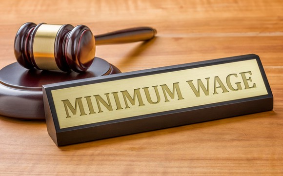 A gavel with a nameplate that says "MINIMUM WAGE" in front of it.