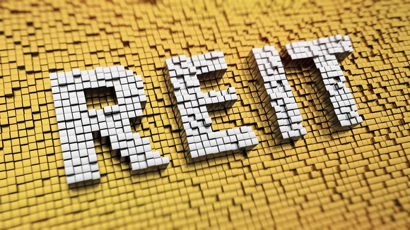 Acronym "REIT" in white on gold background