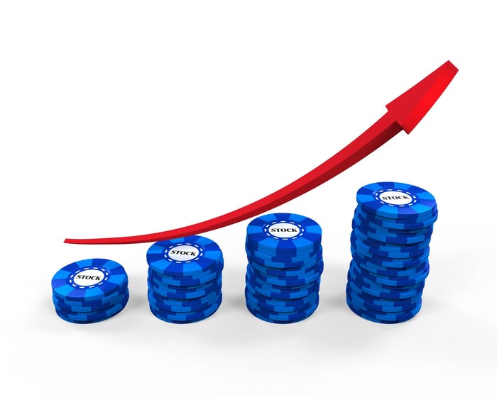 Four piles of blue chips, with a red arrow above them pointing upward.