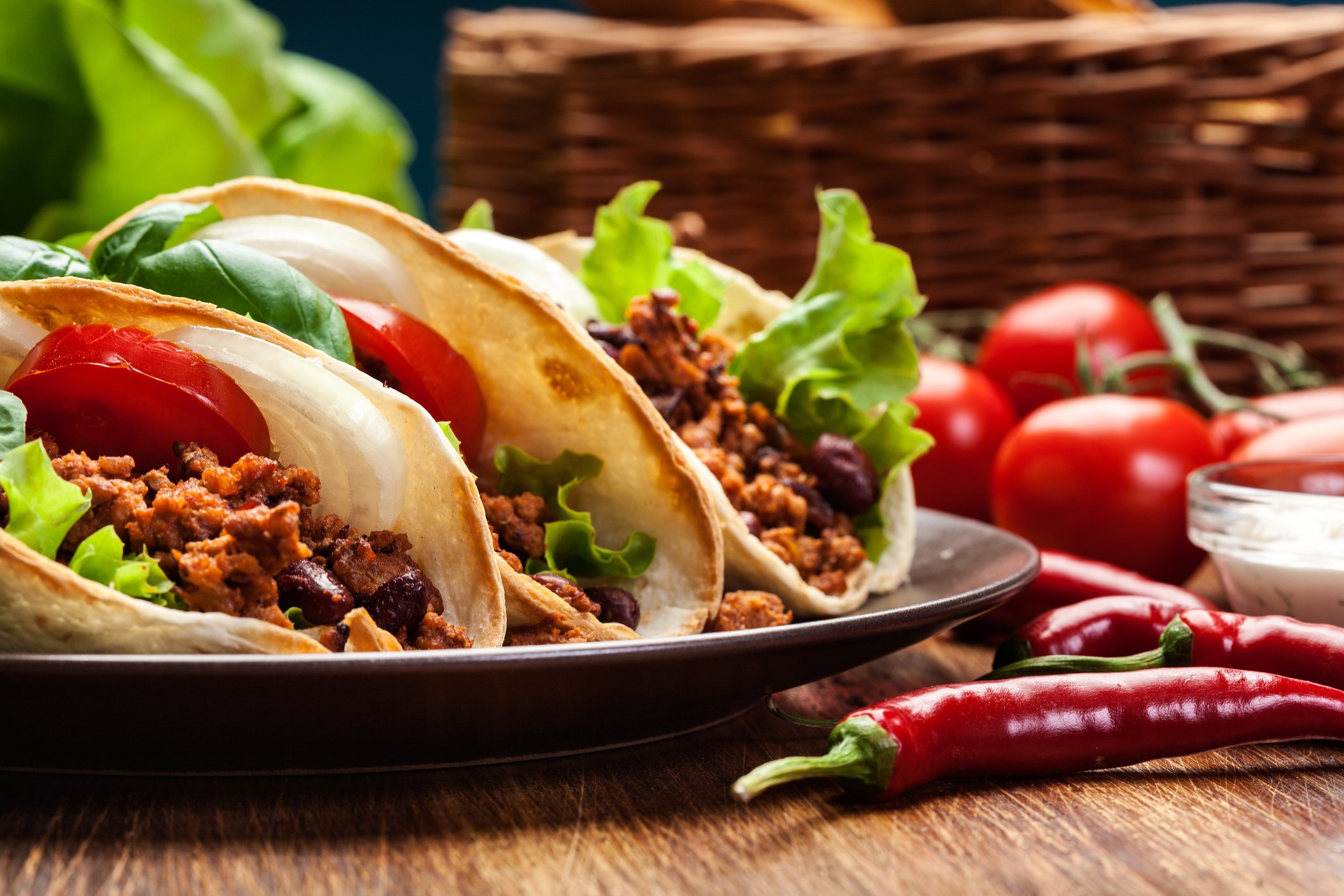 A platter of soft tacos surrounded by fresh ingredients