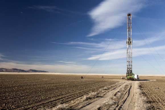 A fracking drill in a open field against a blue sky