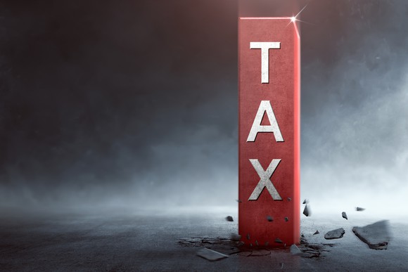 TAX written on a red vertical piece of wood.
