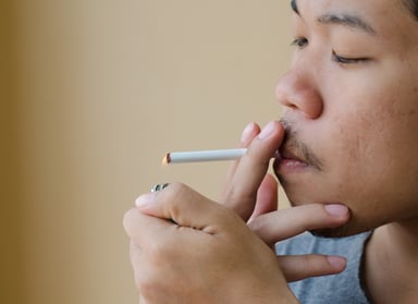 smoking cigarette asian male lighting getty