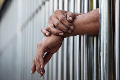 jail prison hands bars prisoner cell getty