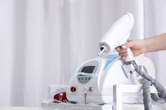 Tattoo removal machine with hand on the laser gun