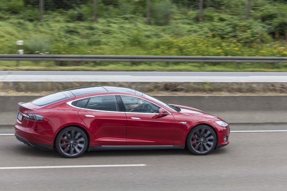 Red Tesla driving down the road