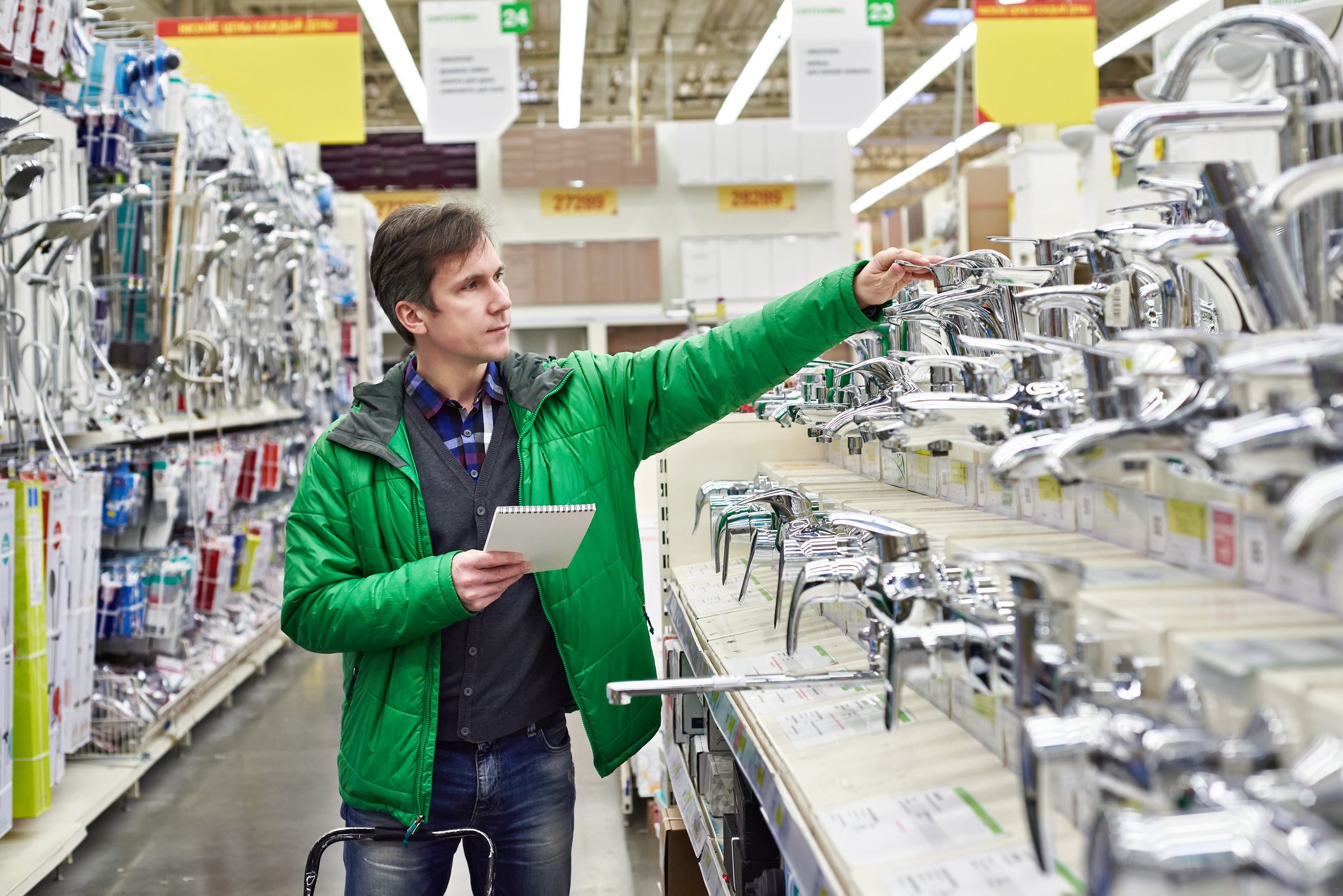 Man examining faucets displayed in home improvement store