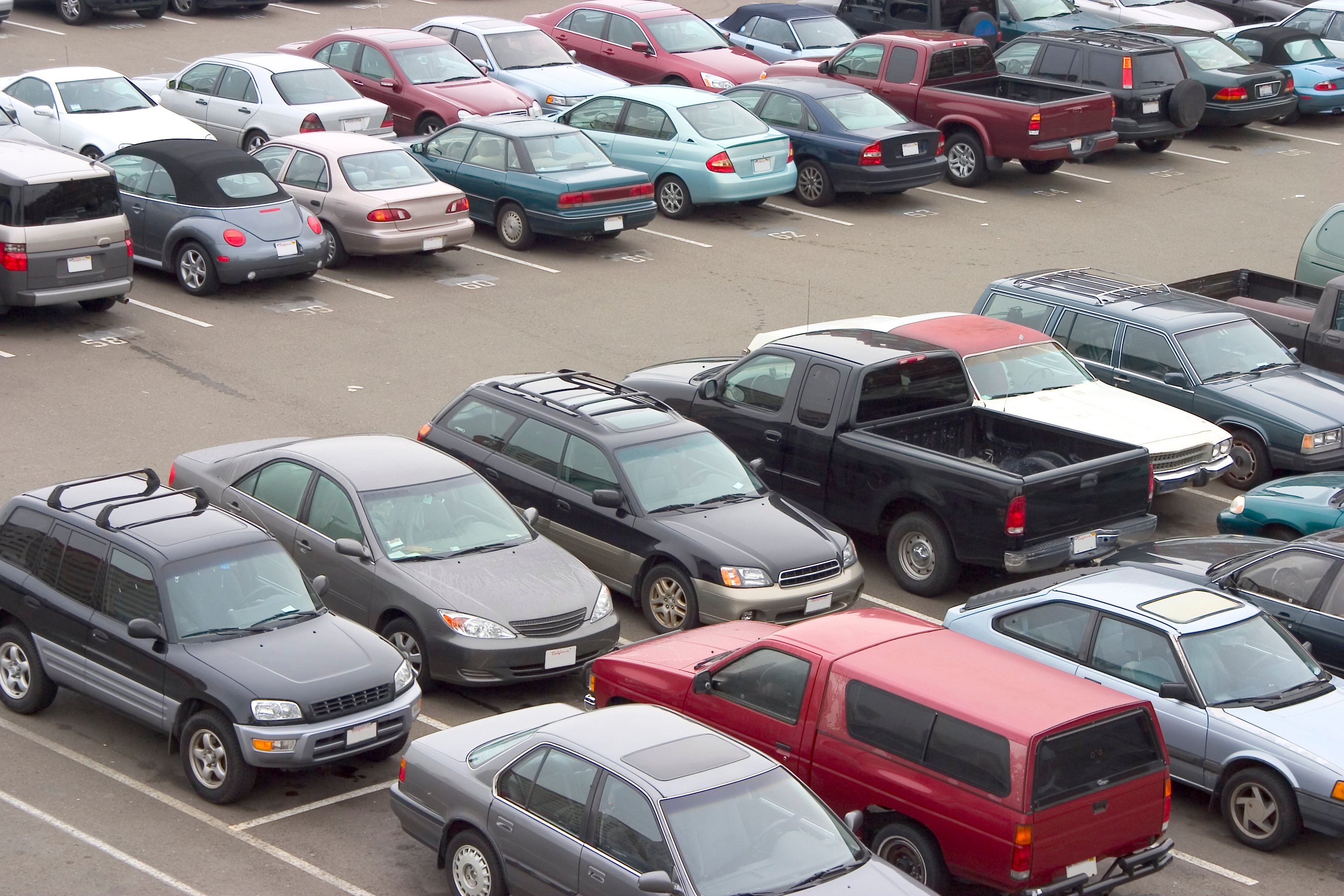A variety of cars and SUVs in a parking lot.