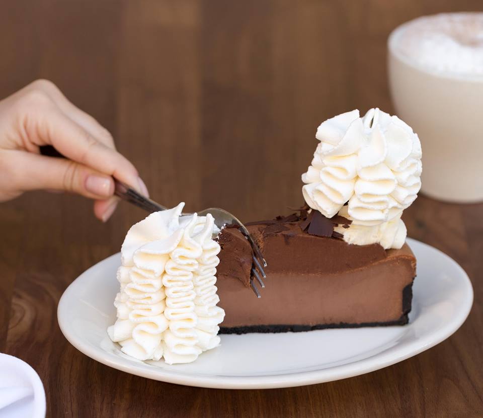 A person digging into a slice of pie from the Cheesecake Factory. 