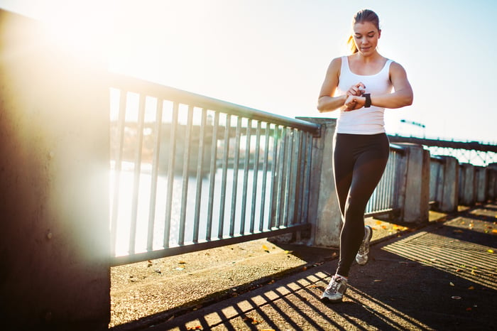 A jogger checks her fitness device.