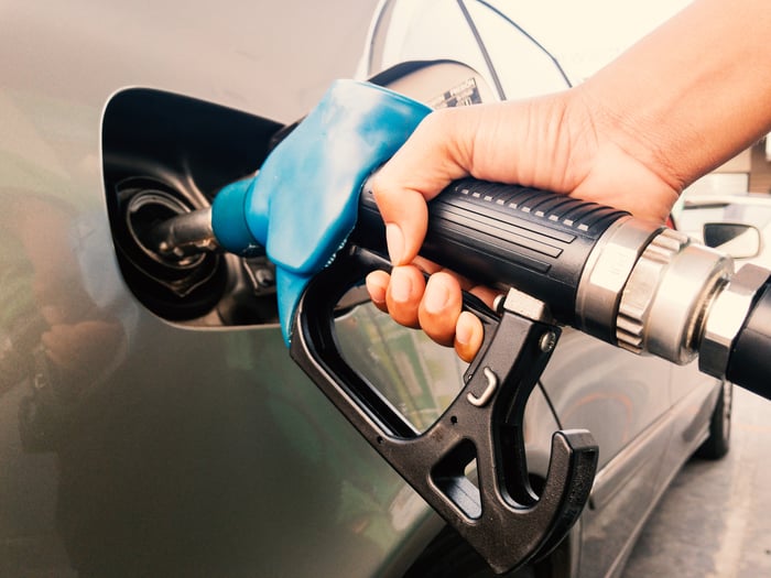 A hand pumping gas into a car.