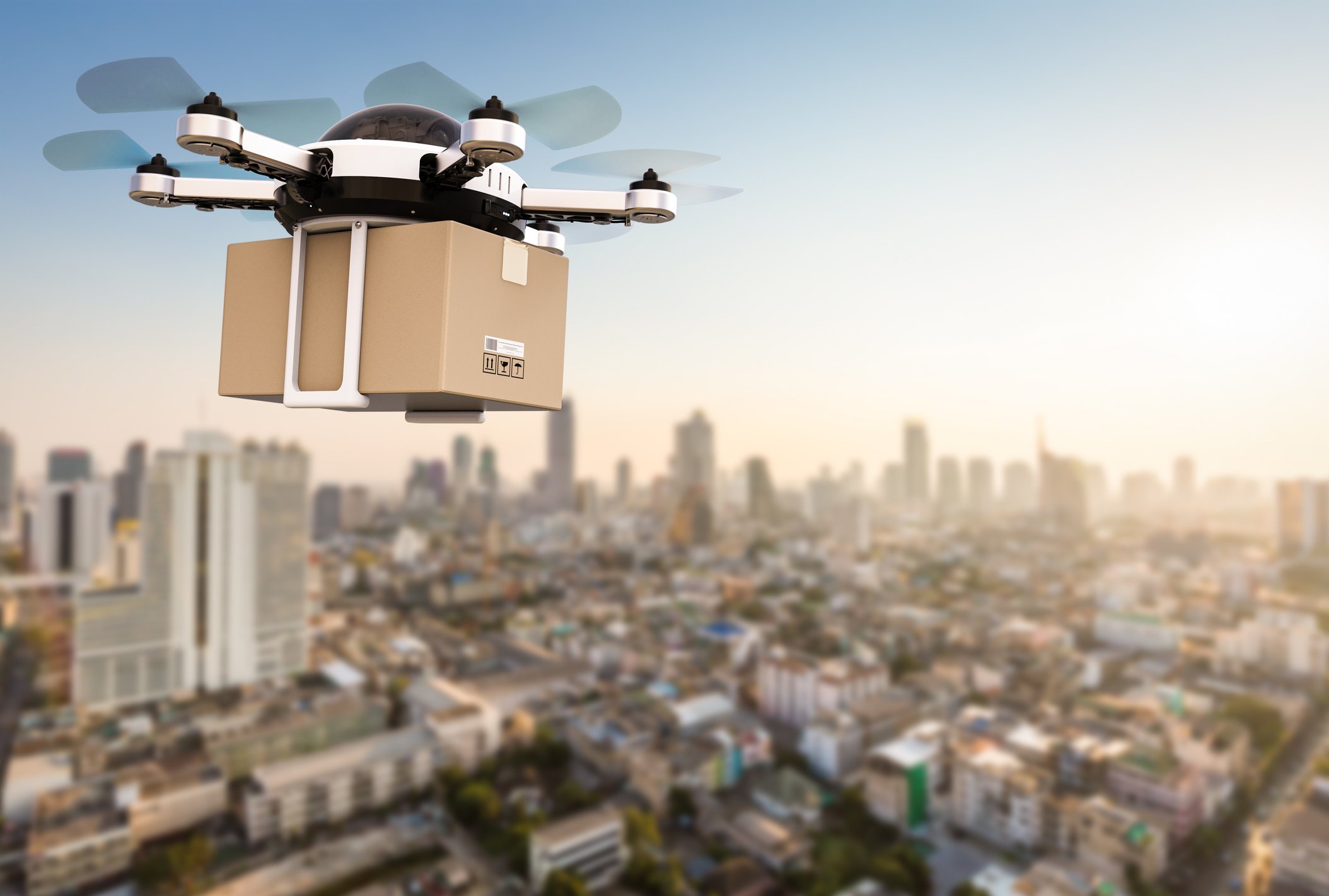 A drone flying a package over a city