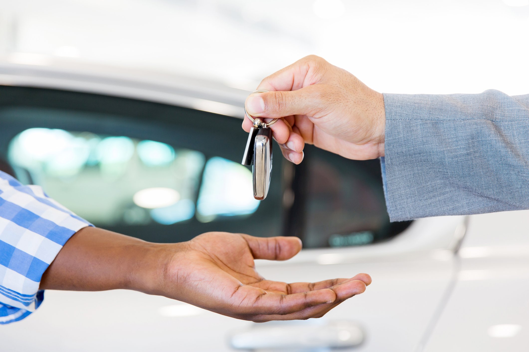A dealer handing over car keys to a customer