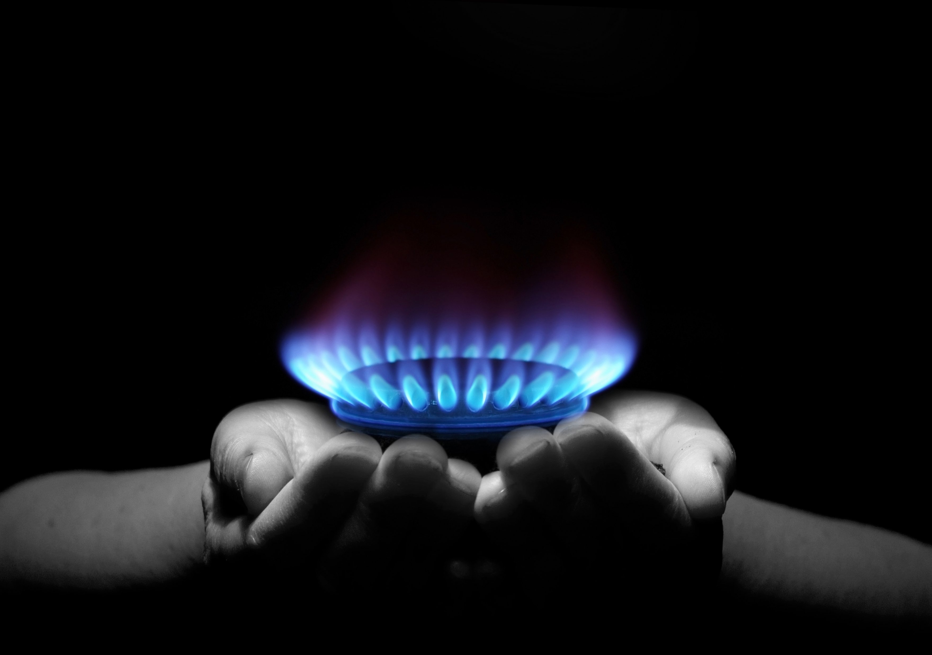 Two cupped hands holding a ring of natural gas flames.