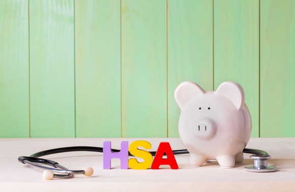 Piggy bank next to stethoscope and acronym HSA