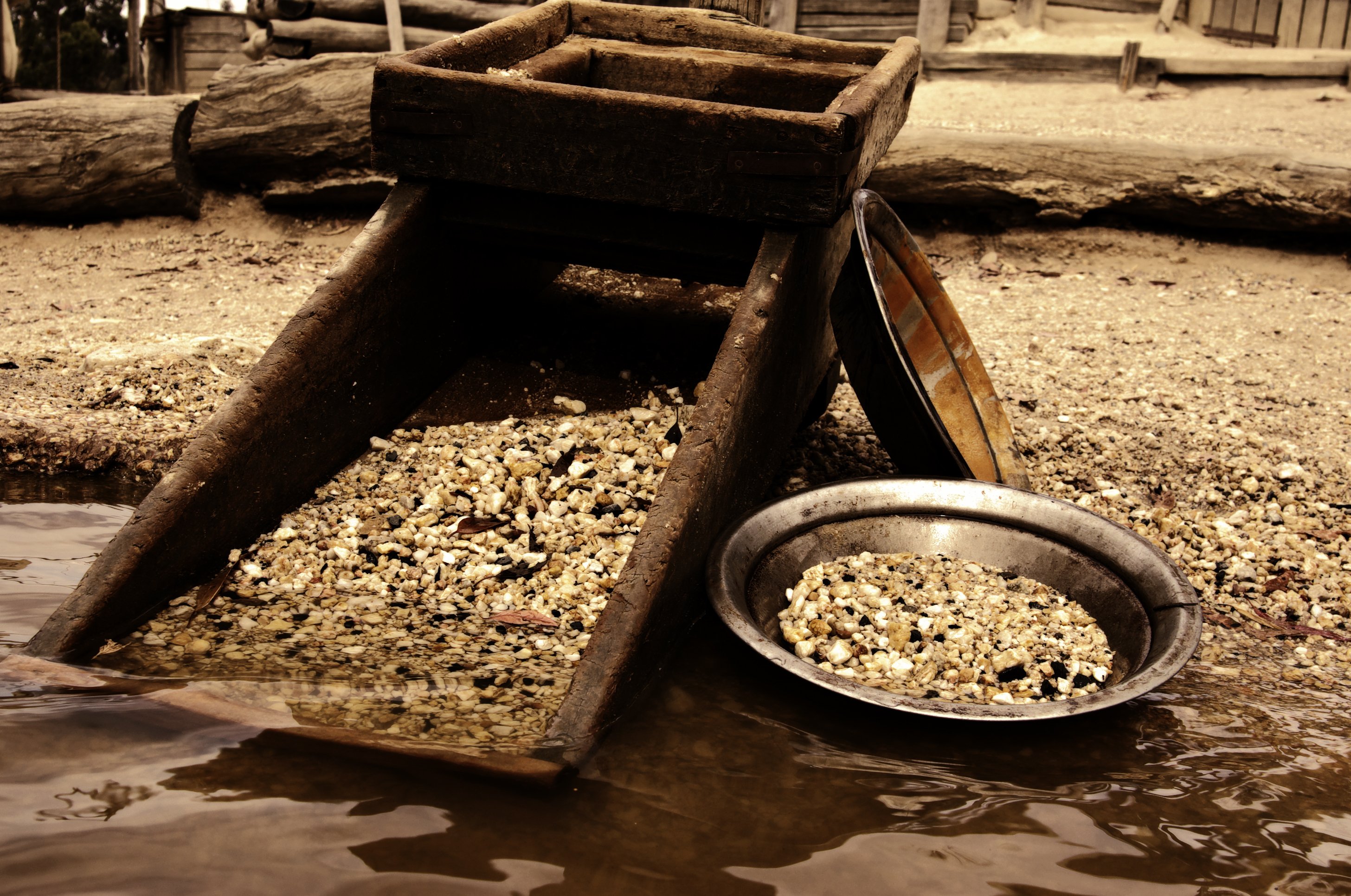 Cart and pan full of gold nuggets. 