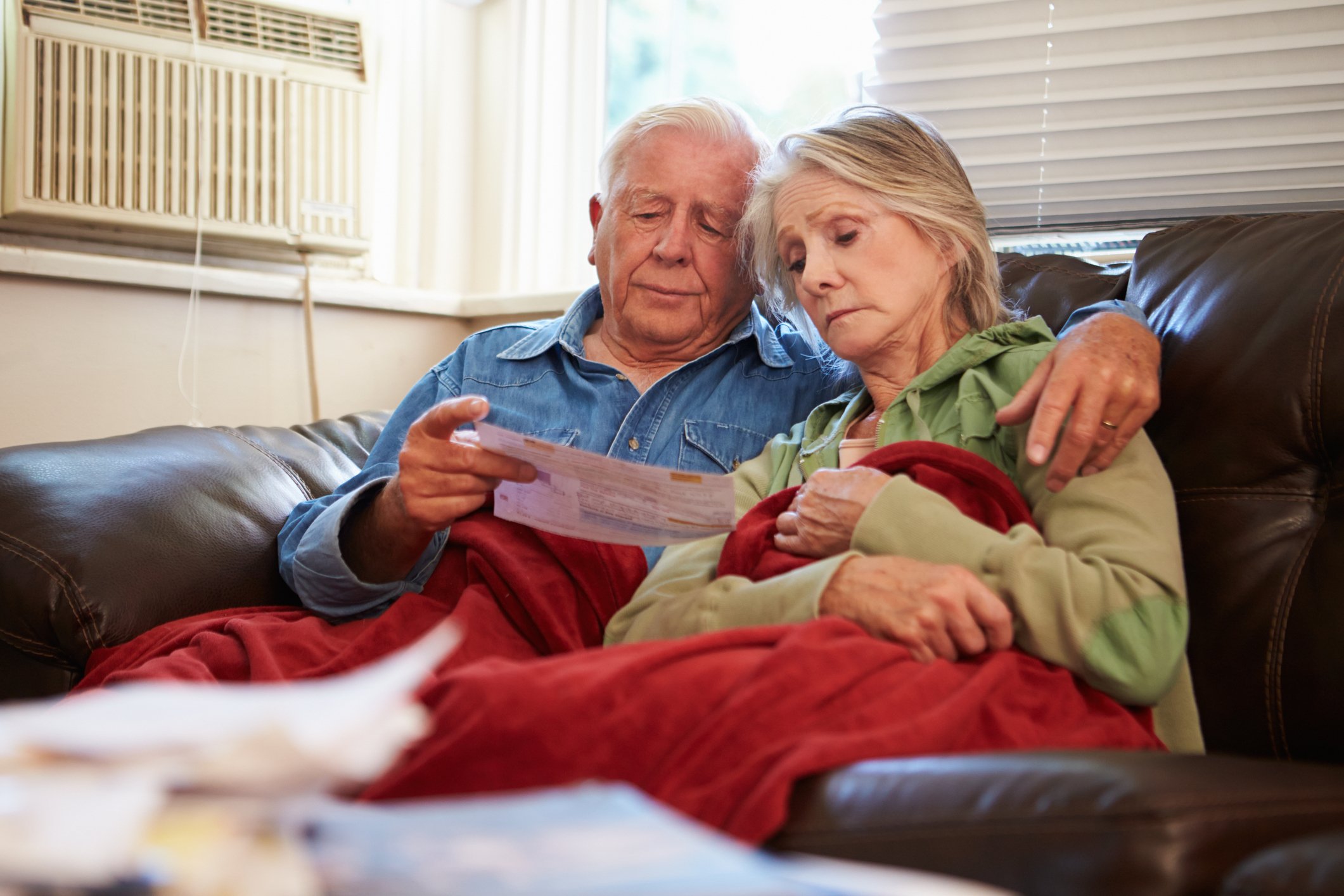 Senior couple examining bills, worried about debt