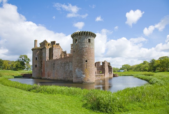 A stone castle surrounded by a moat.