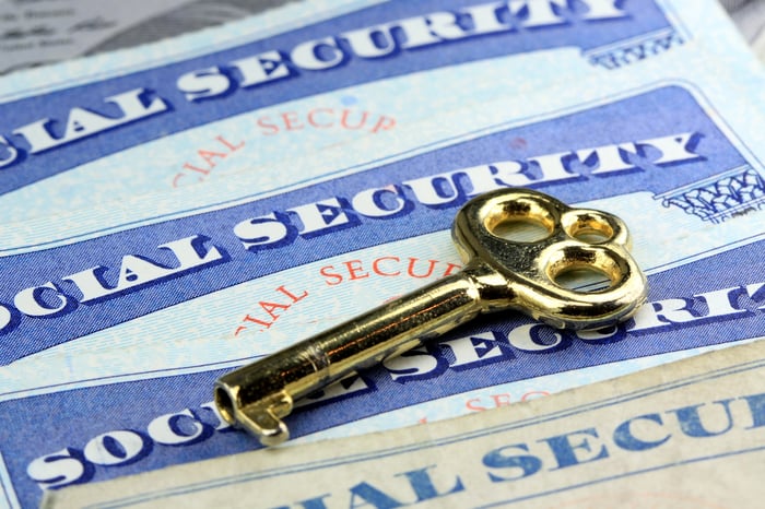 Multiple Social Security cards with a brass key.