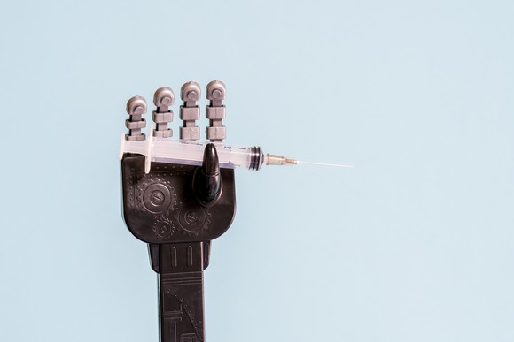 Robot hand holding a syringe