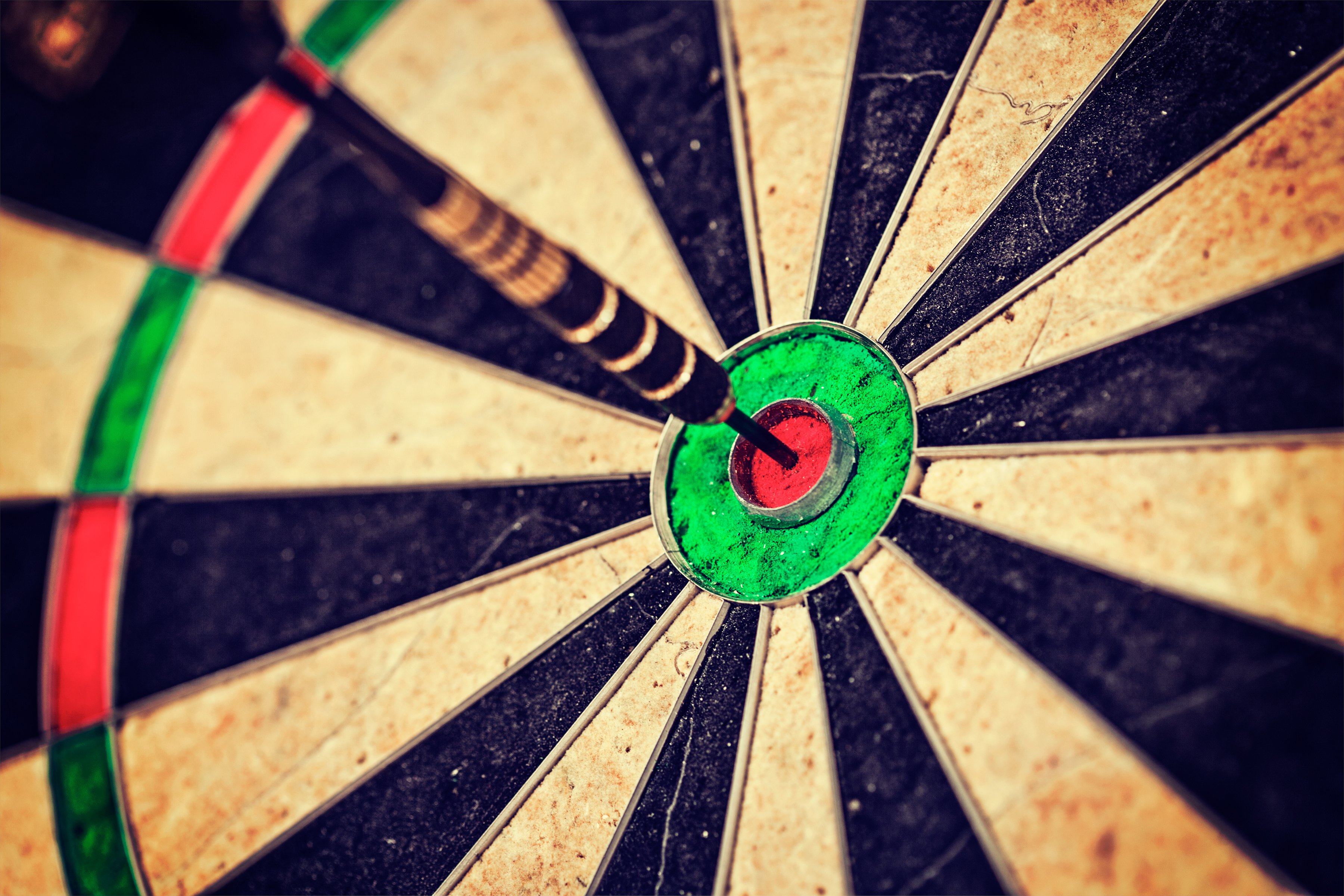 A single dart hitting the bull's-eye of a dart board.