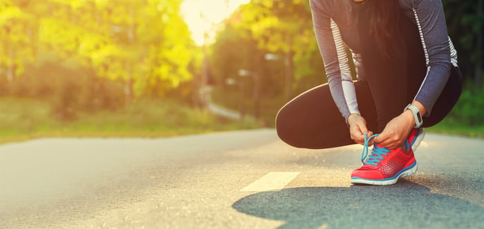 Woman lacing her shoes before an early morning run.