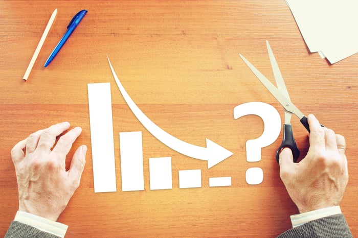 Cut-out pieces of paper forming a chart with a down arrow.
