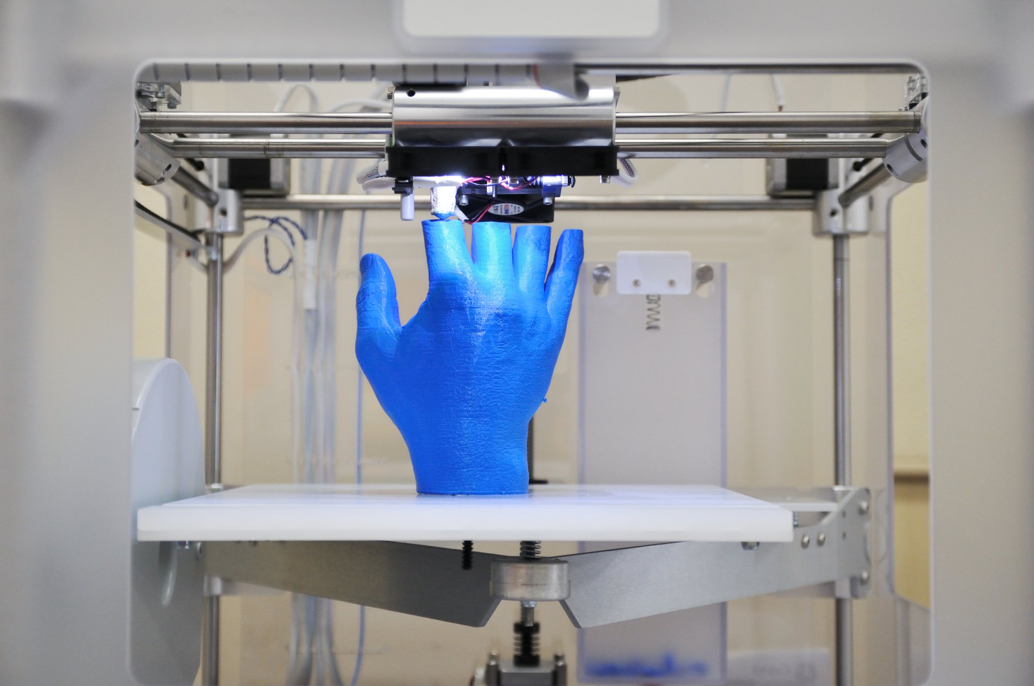 3D printer printing a blue hand.