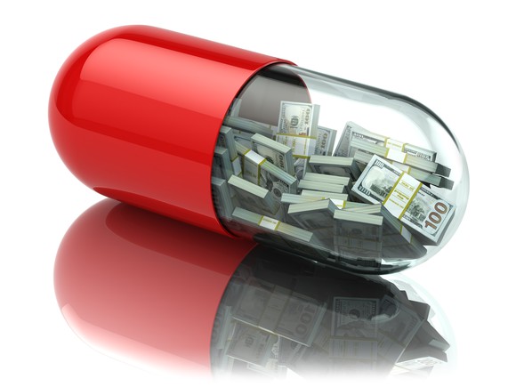 Stacks of money inside a giant pill