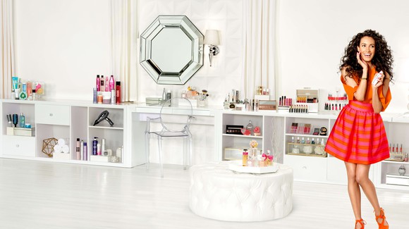 Woman standing in a beauty salon filled with various beauty products.