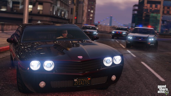 Screenshot of "Grand Theft Auto V" featuring a man in a car being chased by three police cars.