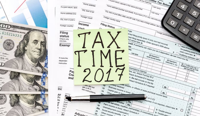 Tax paperwork, cash, a calculator, and a post it note that says "Tax Time 2017".