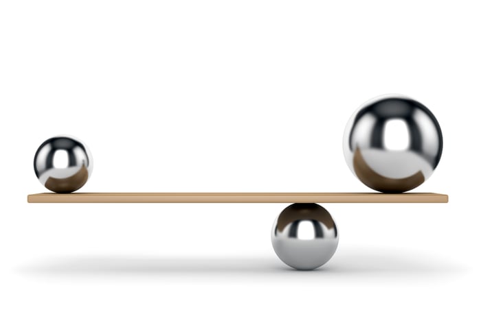 Metal balls balancing on plank