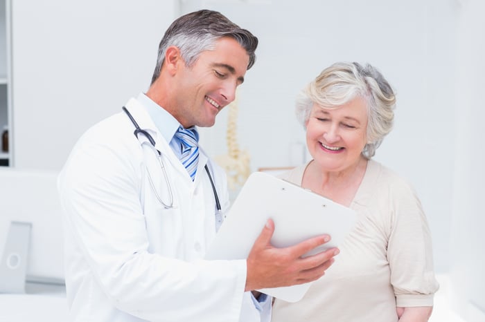 Doctor reviewing paperwork with an elderly female patient. 