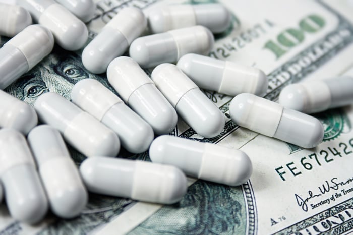 Pills sitting atop a pile of cash. 
