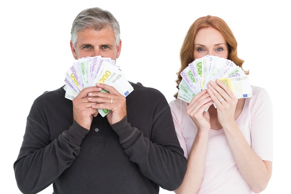 Older couple holding money in front of their faces