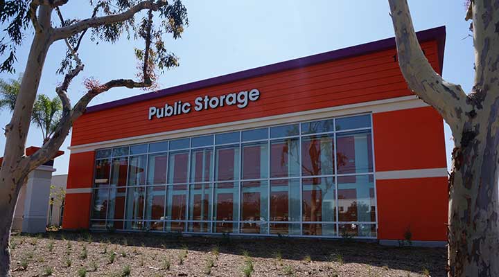 The front-door view of a newly built Public Storage facility, featuring the company's bright orange colors.