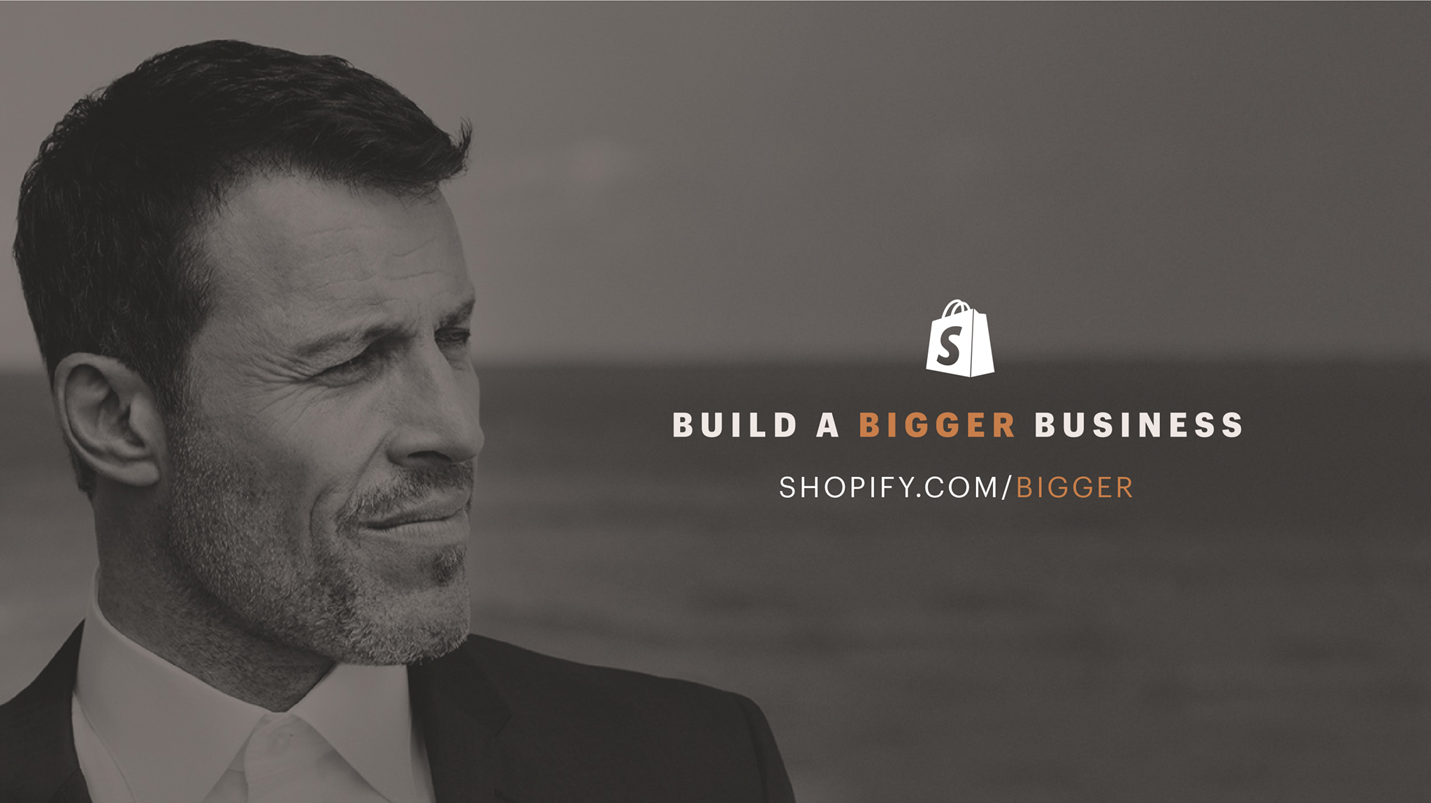 Tony Robbins looking at a logo for Shopify's Build a Bigger Business competition.