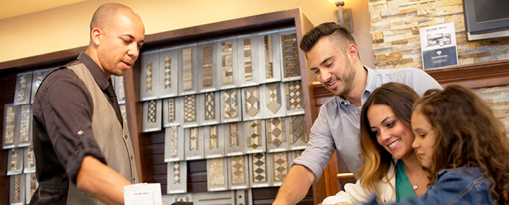 Tile Shop employee helping customers select tile. 
