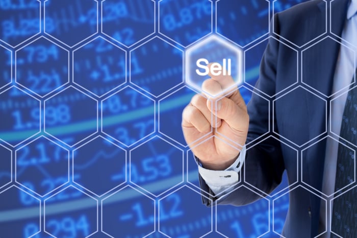 Man pushing sell button on grid