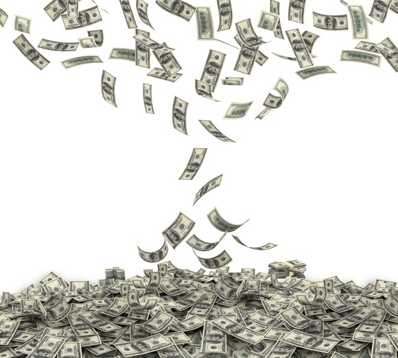 Money falling into large pile