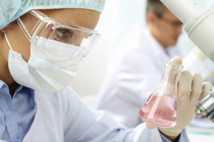 Lab researcher examining liquid. 