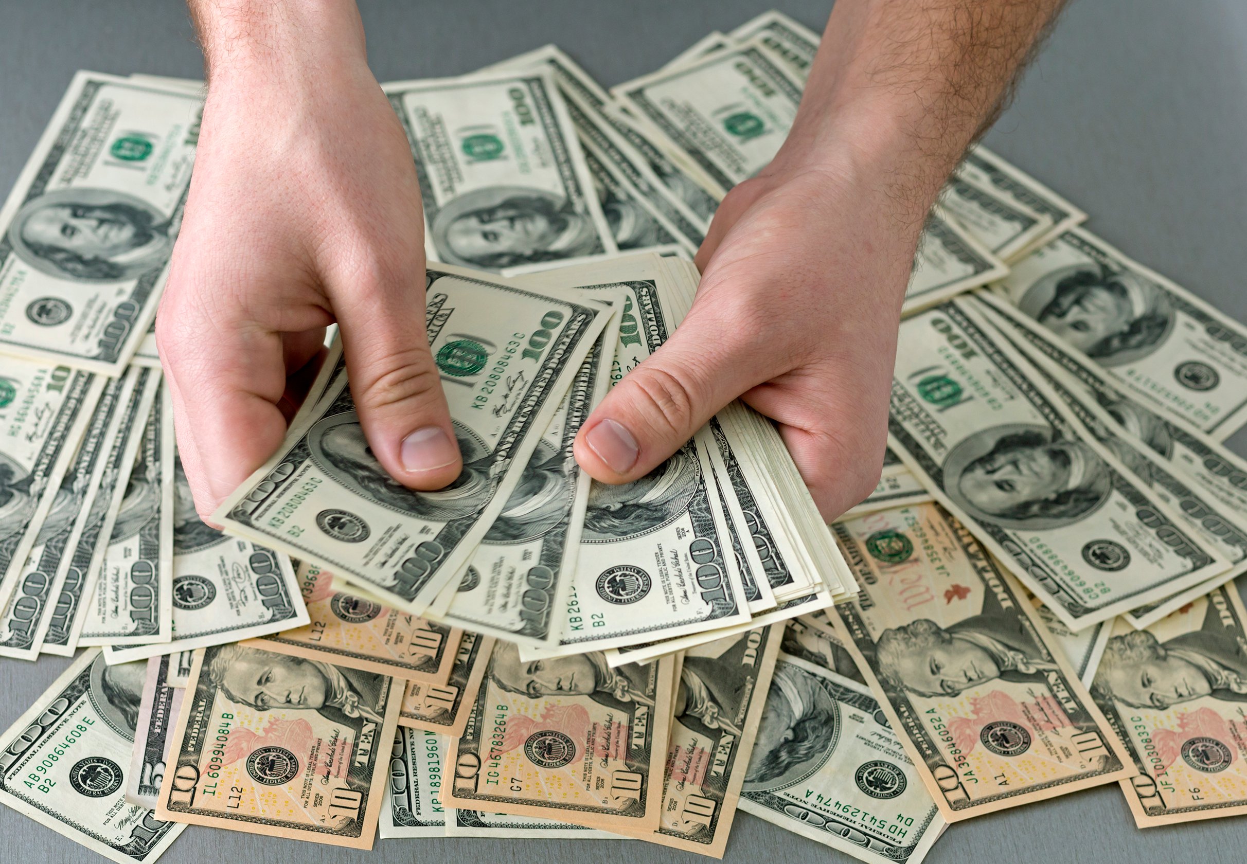 hands holding stacks of bills