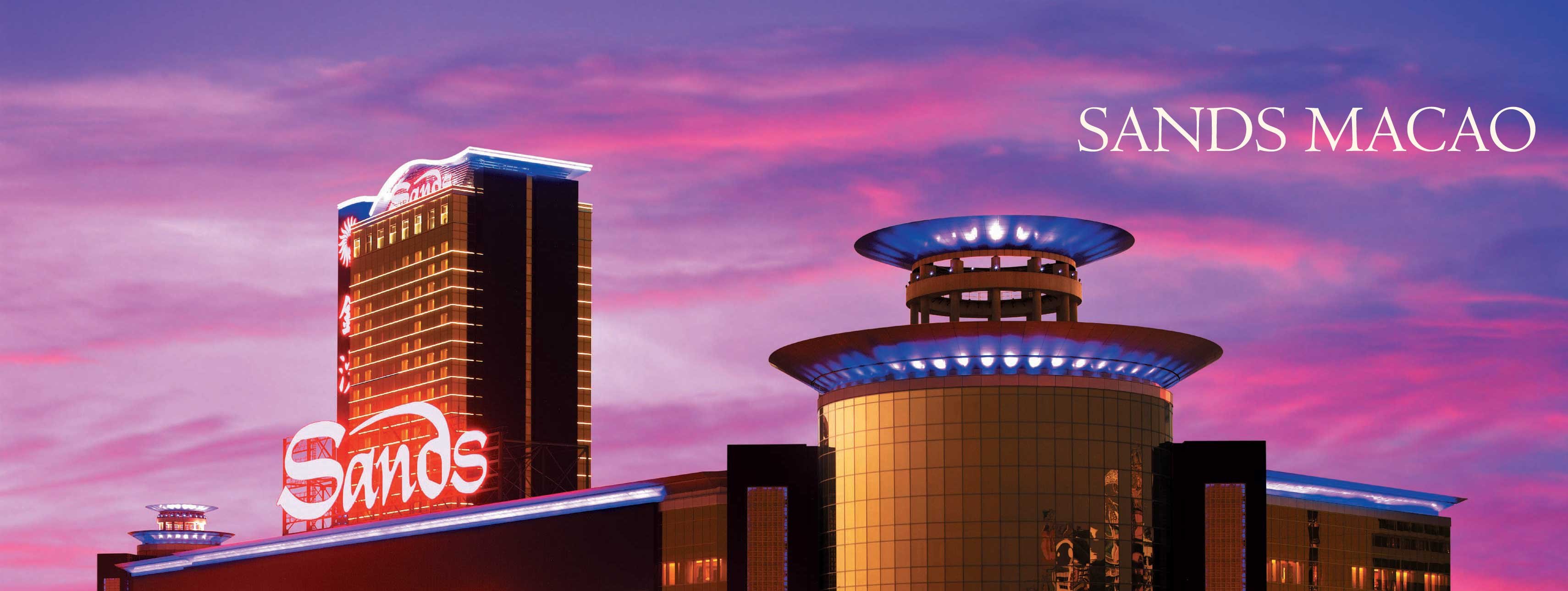The Sands Macao casino in Macau, China in front of a pink and blue sky. 