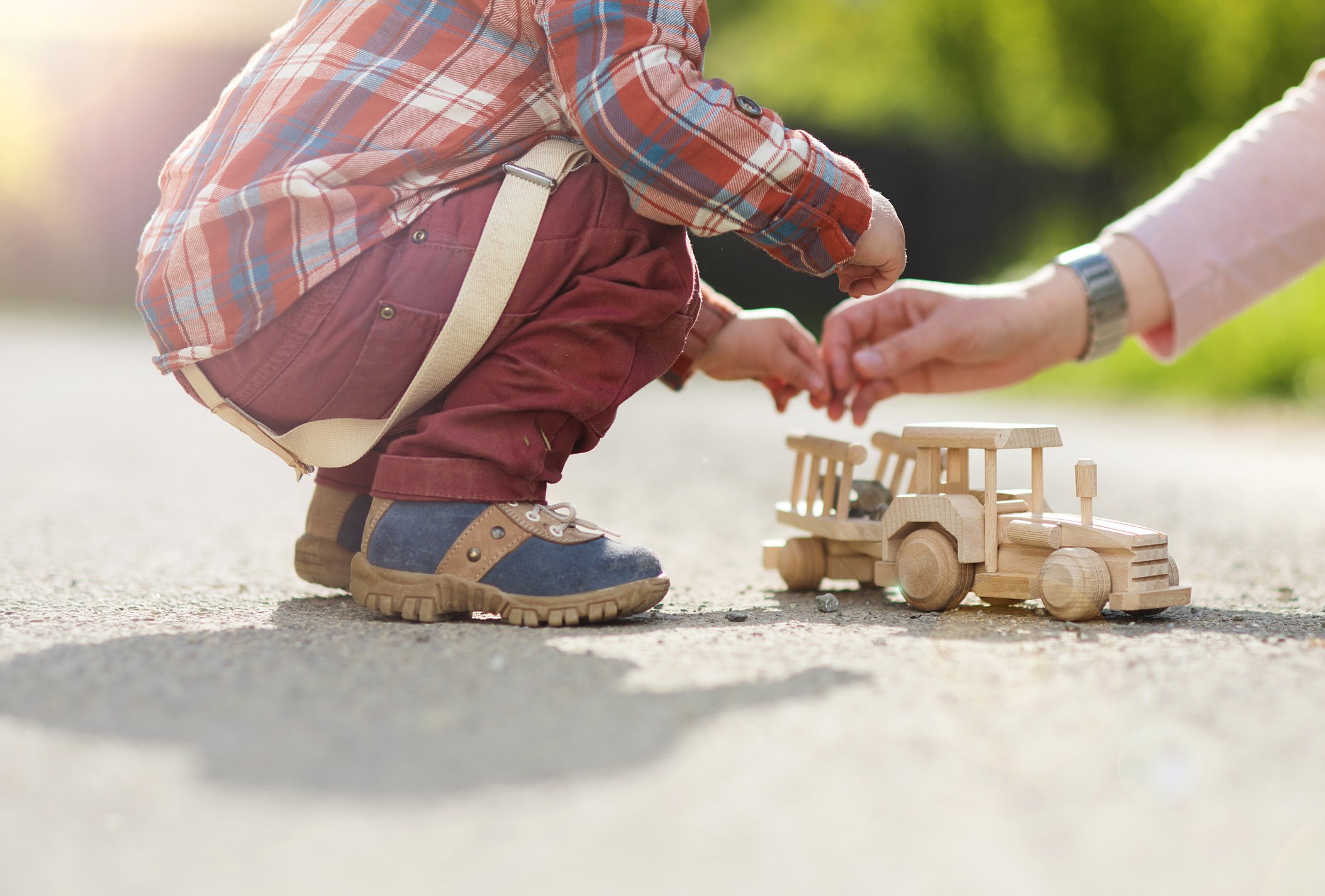 Boy playing with toy tractor.