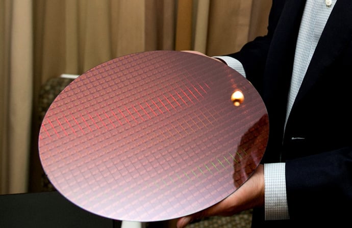 This image shows an Intel employee holding a wafer of chips manufactured in the company's 14-nanometer technology.  