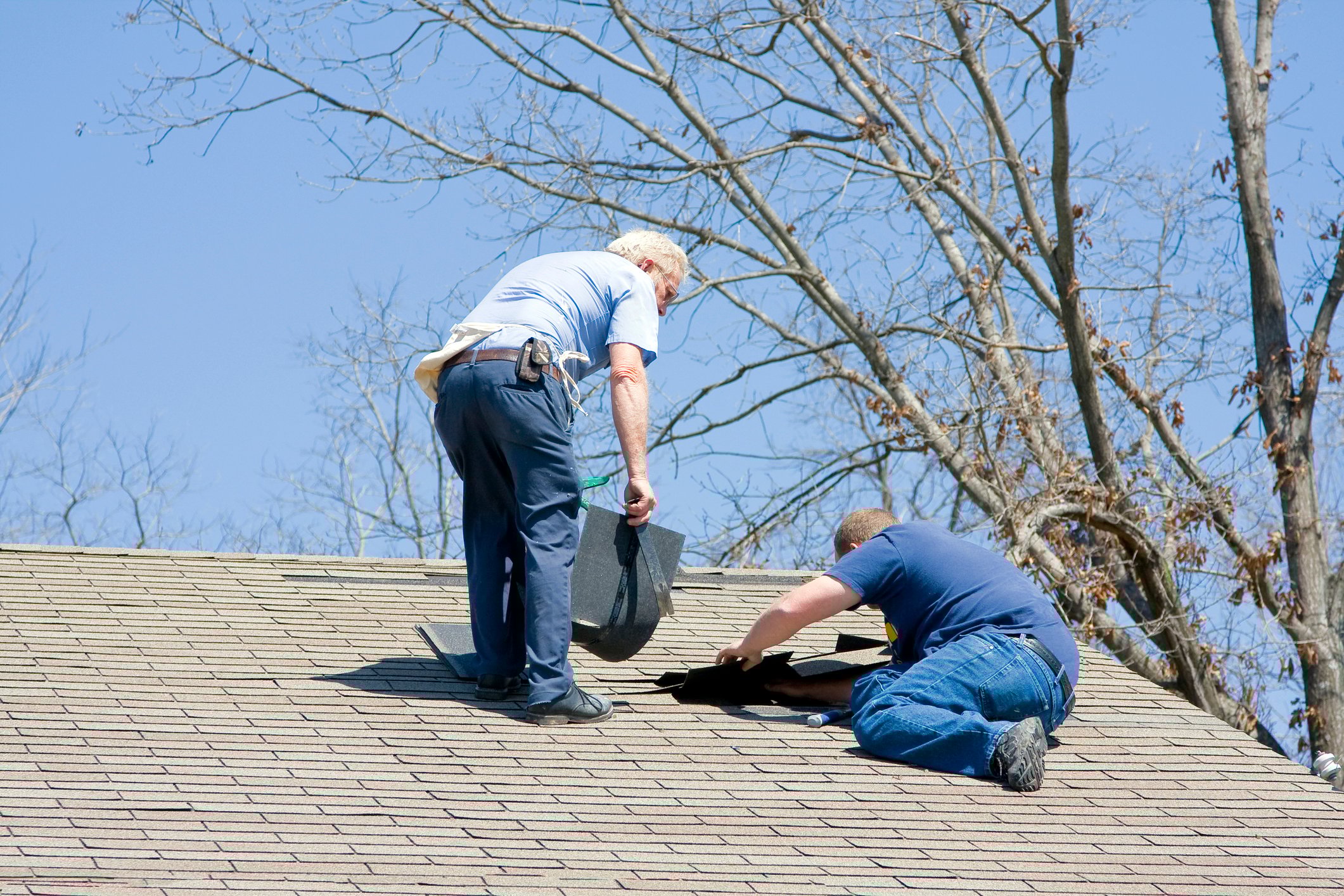 Workers repairing a house's roof