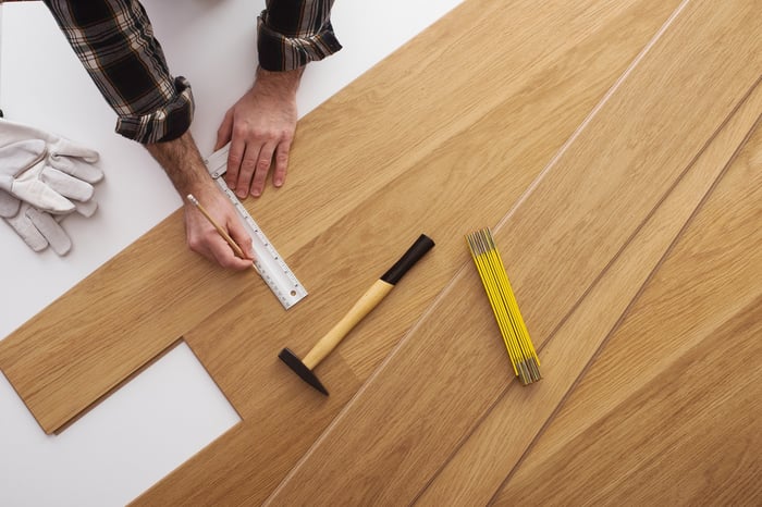 Installer laying wood flooring. 