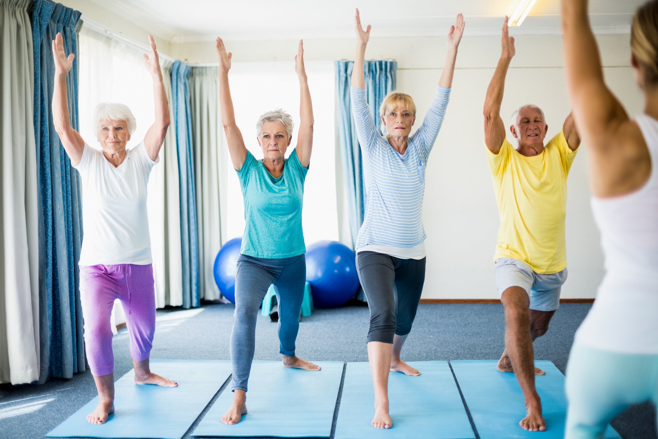 Four older people in a yoga class