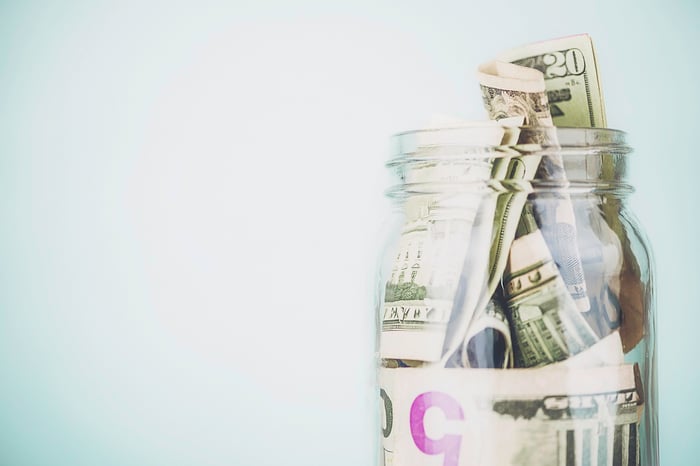 Jar stuffed with U.S. dollar bills of all denominations.